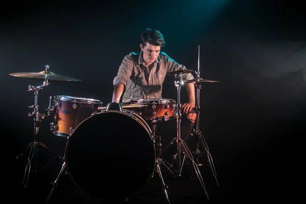 Музикант грає на барабанах, чорний фон і красиве м'яке світло — стокове фото