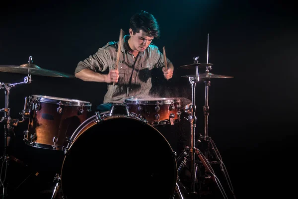 Músico tocando bateria com salpicos, fundo preto com beau — Fotografia de Stock