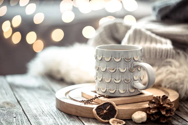 Coffee cup over Christmas lights bokeh in home on wooden table w — Stock Photo, Image