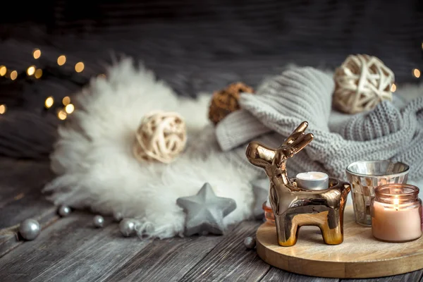 Christmas festive background with toy deer, blurred background with golden lights and candles, festive background on wooden deck table