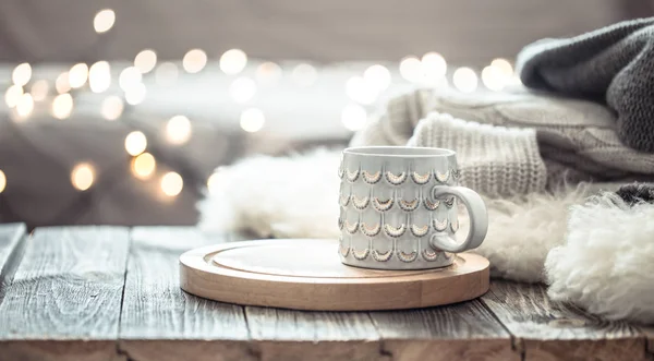 Coffee cup over Christmas lights bokeh in home on wooden table w — Stock Photo, Image