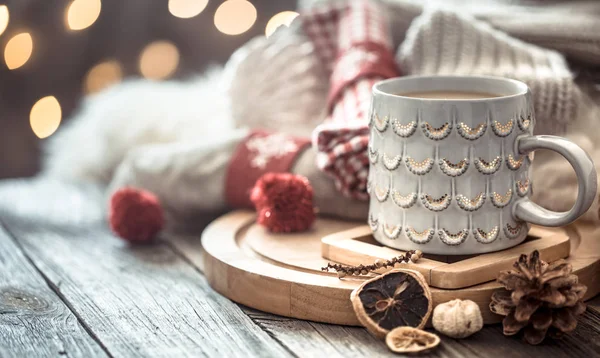 Coffee cup over Christmas lights bokeh in home on wooden table w — Stock Photo, Image