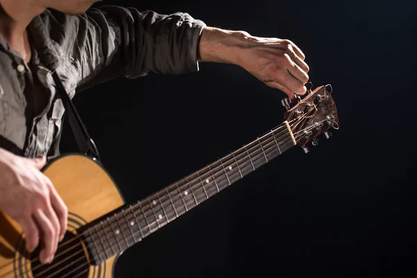 Guitarrista, música. Um jovem toca guitarra acústica num blac — Fotografia de Stock