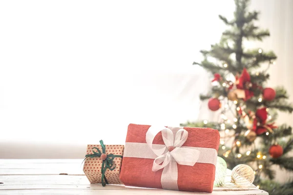 Regalo de Navidad rojo sobre luces de Navidad y árbol de Navidad o —  Fotos de Stock