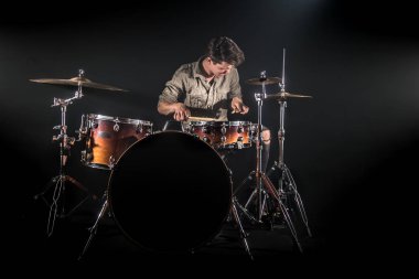 Profesyonel davulcu siyah b üzerinde sahnede set davul oynuyor