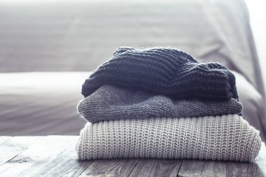 Ahşap bir masa üzerinde örme kazak yığını
