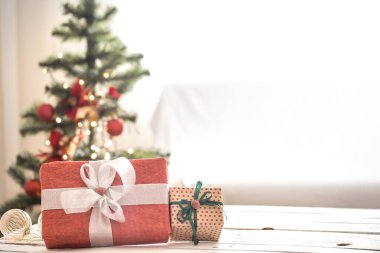 Wi yakın ahşap masada ışık arka plan üzerinde kırmızı Noel hediyesi