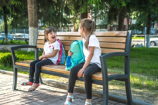 Zurück zur Schule. fröhliche niedliche fleißige Kinder auf der Bank sitzen — Stockfoto