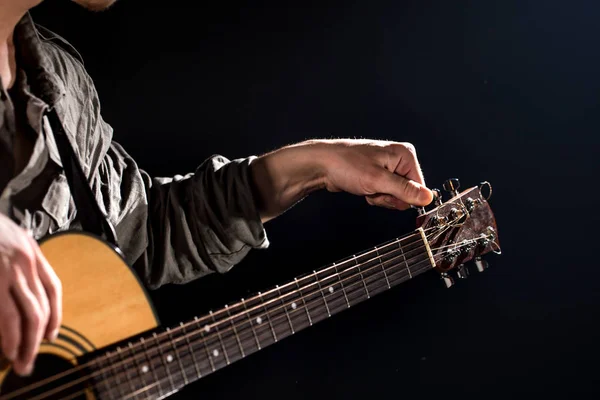 Guitarrista, música. Um jovem toca guitarra acústica num blac — Fotografia de Stock