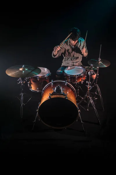 Музикант грає на барабанах, чорний фон і красиве м'яке світло — стокове фото