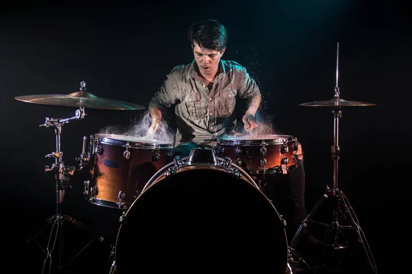 Músico tocando bateria com salpicos, fundo preto com beau — Fotografia de Stock