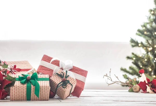 Hromada vánočních dárků nad světlým pozadím na dřevěném stole — Stock fotografie