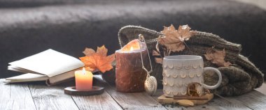 Yatakta natürmort sahnesinde rahat sonbahar sabah kahvaltısı. Buğulama fincanı sıcak kahve, pencerenin yanında duran çay. Sonbahar.