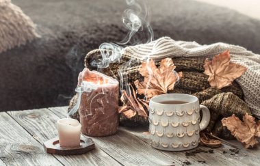 Yatakta natürmort sahnesinde rahat sonbahar sabah kahvaltısı. Buğulama fincanı sıcak kahve, pencerenin yanında duran çay. Sonbahar.