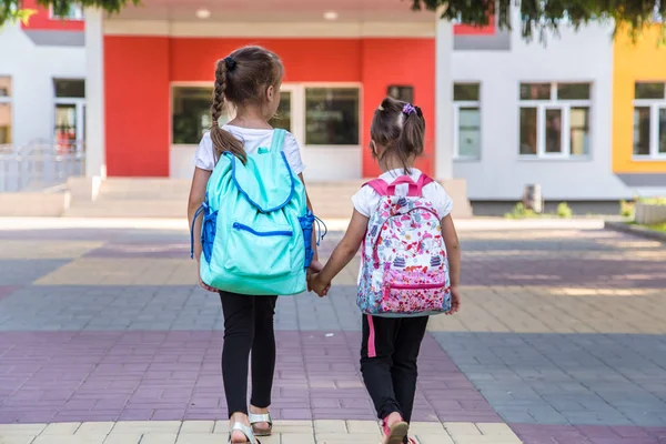 Back to school education concept with girl kids, elementary students, carrying backpacks going to class — Stock Photo, Image