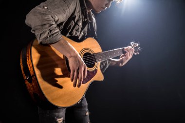Gitarist, müzik. Genç bir adam siyah bir izole arka planda akustik gitar çalar