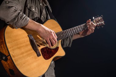 Gitarist, müzik. Genç bir adam siyah bir izole arka planda akustik gitar çalar