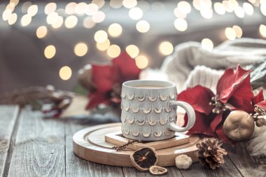 Noel ışıkları bokeh üzerinde Kahve fincanı bir arka plan ve süslemeleri üzerinde çiçekler ile ahşap masada evde bokeh. Tatil dekorasyon, sihirli Noel