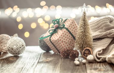 Noel ışıkları bokeh üzerinde Noel ağacı süslemeleri bir arka plan ve süslemeleri kazak ile ahşap masada evde. Tatil dekorasyonu