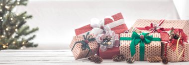 Ahşap masa üzerinde ışık arka plan üzerinde Noel hediyeleri yığını. Noel süsleri