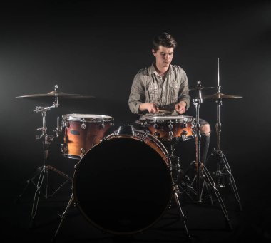 Profesyonel davulcu siyah b üzerinde sahnede set davul oynuyor