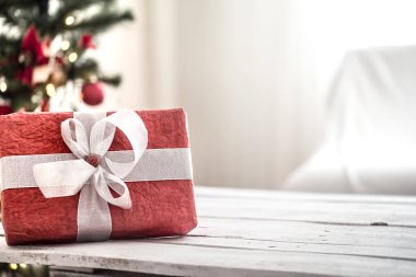 Wi yakın ahşap masada ışık arka plan üzerinde kırmızı Noel hediyesi