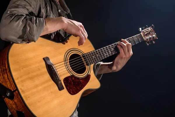 Guitarrista, música. Um jovem toca guitarra acústica num blac — Fotografia de Stock