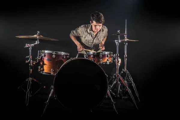 Batteur professionnel jouant sur le tambour mis en scène sur le b noir — Photo