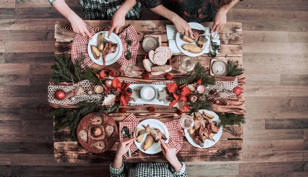 Arkadaşların elleri birlikte yiyip içiyor. Ahşap rustik masada birlikte parti yapan, toplayan, kutlayan insanların üst görünümü