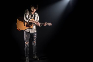 Gitarist, müzik. Genç bir adam bir blac üzerinde akustik gitar oynar