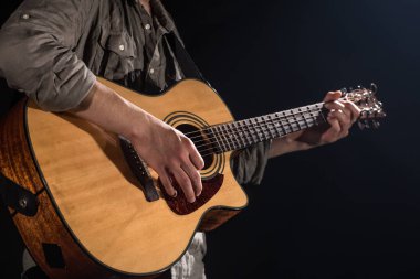 Gitarist, müzik. Genç bir adam bir blac üzerinde akustik gitar oynar