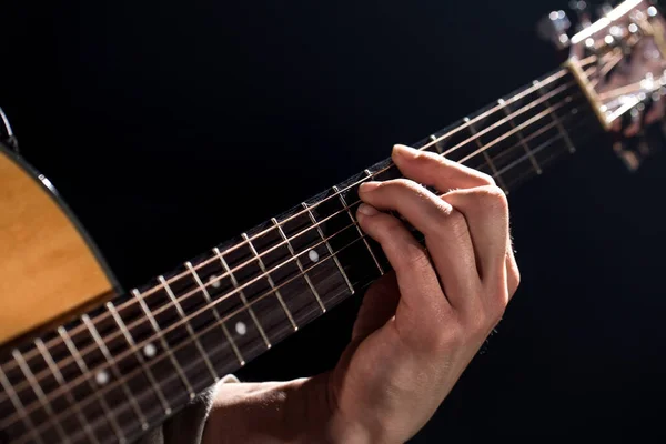 Gitarrist, musik. En ung man spelar en akustisk gitarr på en blac — Stockfoto