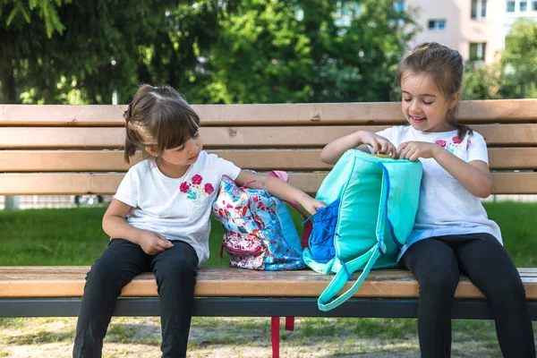 Torniamo a scuola. Felice carino bambini laboriosi seduti sulla panchina — Foto Stock