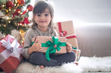 Güzel küçük kız bir hediye kutusu tutuyor ve zaman Sitti gülümseyen