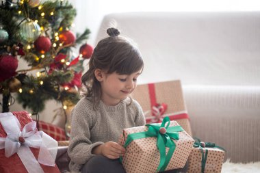 Güzel küçük kız bir hediye kutusu tutuyor ve zaman Sitti gülümseyen