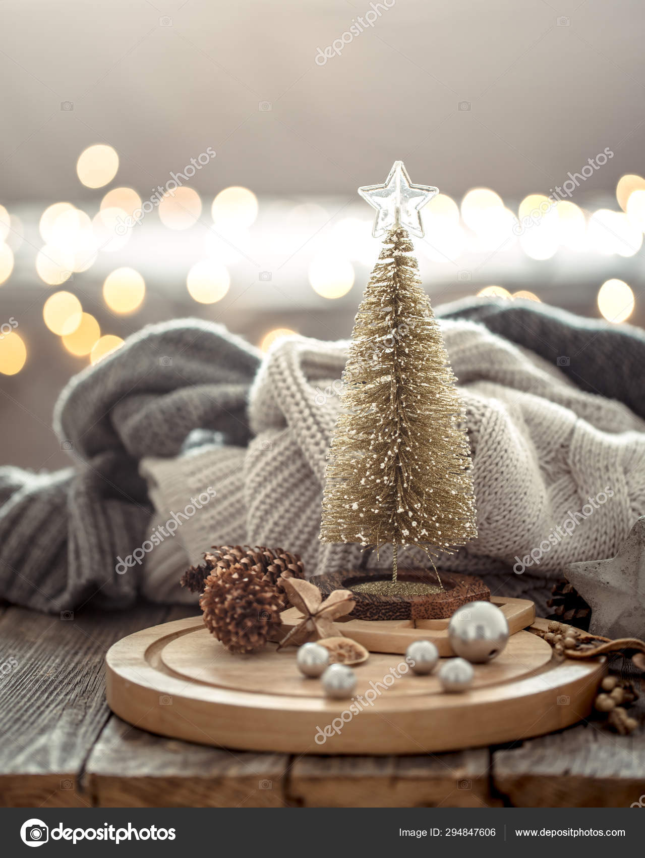 小圣诞树在圣诞灯散景在家里的木桌上与毛衣的背景和装饰。假日装饰——图库图片© puhimec #294847606, image size:1279x1700