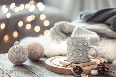 Noel ışıkları bokeh üzerinde Kahve fincanı bir arka plan ve süslemeleri üzerinde kazak ile ahşap masada evde bokeh. Tatil dekorasyon, sihirli Noel