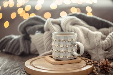 Noel ışıkları bokeh üzerinde Kahve fincanı bir arka plan ve süslemeleri üzerinde kazak ile ahşap masada evde bokeh. Tatil dekorasyon, sihirli Noel