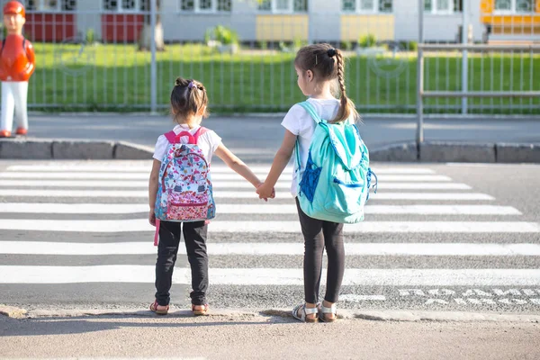 Back to school education concept with girl kids, elementary students, carrying backpacks going to class — Stock Photo, Image