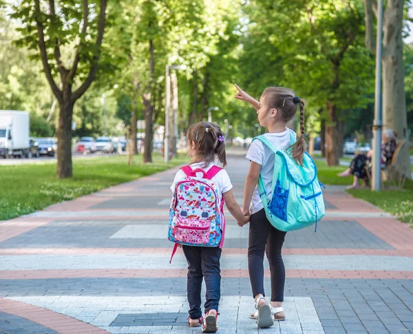 Back to school education concept with girl kids, elementary students, carrying backpacks going to class — Stock Photo, Image