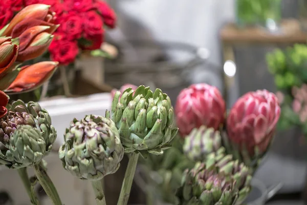 Exotic flowers are the red Amaryllis, artichoke and Protea flowers in a flower shop