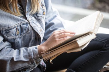 Bir kafede oturan ve kitap okuyan genç kız