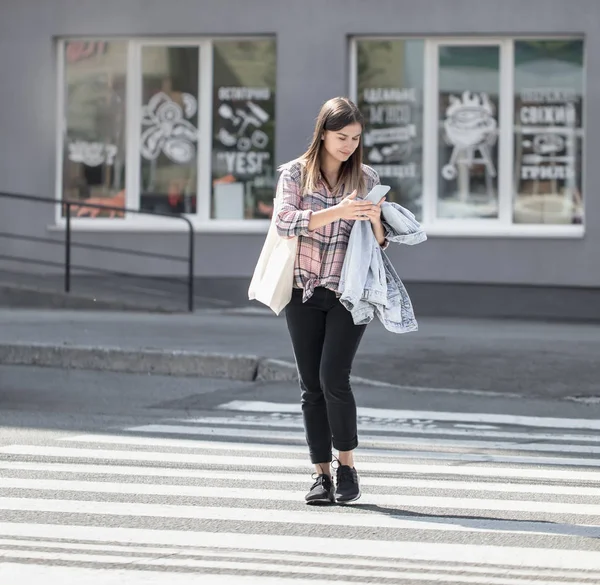 Chica joven cruzando la calle en un cruce peatonal con eco b — Foto de Stock