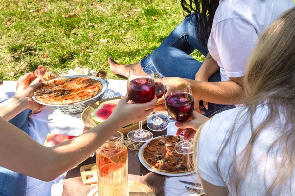 Summer picnic with friends in nature with food and drinks.