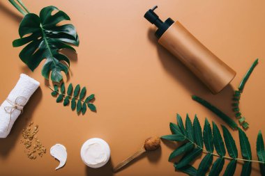 Doğal spa düz kahverengi arka plan üzerinde yeşilçerçeveli şişe mock ile kompozisyon yatıyordu