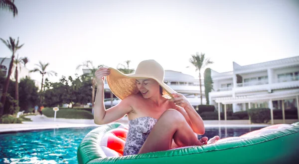 Havuz başında yaz tatili. Kadın havuzda şişme daire üzerinde rahatlatır.