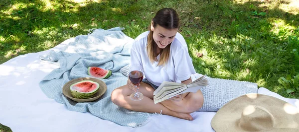 Une jeune femme à un pique-nique lisant un livre — Photo