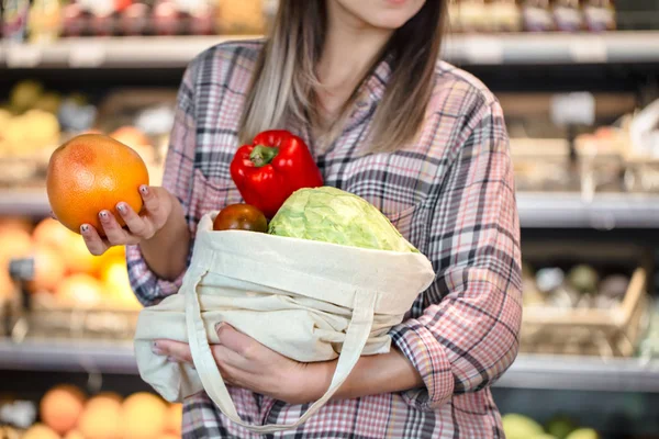 Menina segurando frutas e legumes em um saco ecológico na ba — Fotografia de Stock