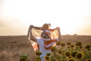Gün batımında Amerikan bayrağı olan mutlu bir aile.