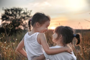 Gün batımında tarlada iki küçük kız kardeş.